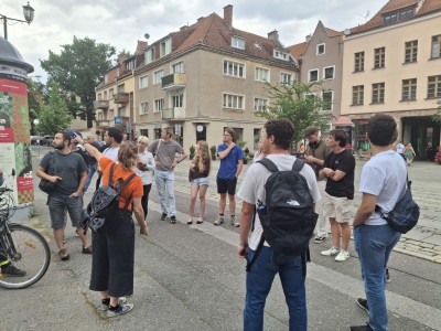 zdjęcia przedstawiają uczestników programu TSSP ExSci 2026 podczas zwiedzania Starówki Torunia z przewodnikiem oraz podczas wykładów naukowych. Kliknij, aby powiększyć zdjęcie.