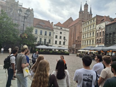 zdjęcia przedstawiają uczestników programu TSSP ExSci 2026 podczas zwiedzania Starówki Torunia z przewodnikiem oraz podczas wykładów naukowych. Kliknij, aby powiększyć zdjęcie.