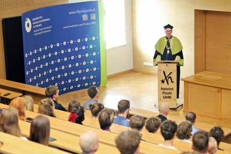 Kadry z inauguracji roku akademickiego w Audytorium Aleksandra Jabłońskiego - kolegium dziekańskie wraz z prorektorką za stołem oraz studenci i nauczyciele oraz administracja siedzący na sali. Kliknij, aby powiększyć zdjęcie.