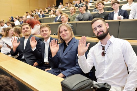Kadry z inauguracji roku akademickiego w Audytorium Aleksandra Jabłońskiego - kolegium dziekańskie wraz z prorektorką za stołem oraz studenci i nauczyciele oraz administracja siedzący na sali. Kliknij, aby powiększyć zdjęcie.
