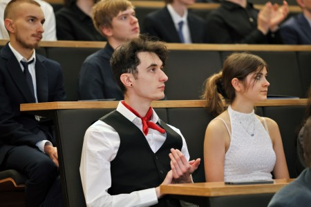 Kadry z inauguracji roku akademickiego w Audytorium Aleksandra Jabłońskiego - kolegium dziekańskie wraz z prorektorką za stołem oraz studenci i nauczyciele oraz administracja siedzący na sali. Kliknij, aby powiększyć zdjęcie.