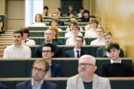 Kadry z inauguracji roku akademickiego w Audytorium Aleksandra Jabłońskiego - kolegium dziekańskie wraz z prorektorką za stołem oraz studenci i nauczyciele oraz administracja siedzący na sali. Kliknij, aby powiększyć zdjęcie.