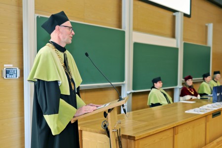 Kadry z inauguracji roku akademickiego w Audytorium Aleksandra Jabłońskiego - kolegium dziekańskie wraz z prorektorką za stołem oraz studenci i nauczyciele oraz administracja siedzący na sali. Kliknij, aby powiększyć zdjęcie.