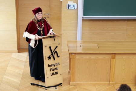Kadry z inauguracji roku akademickiego w Audytorium Aleksandra Jabłońskiego - kolegium dziekańskie wraz z prorektorką za stołem oraz studenci i nauczyciele oraz administracja siedzący na sali. Kliknij, aby powiększyć zdjęcie.