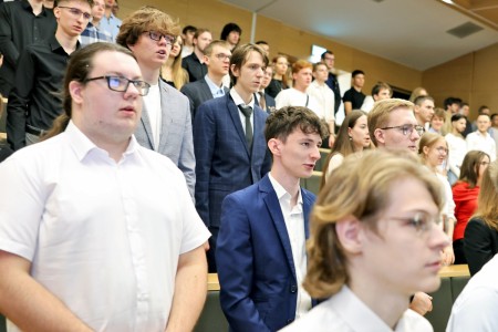 Kadry z inauguracji roku akademickiego w Audytorium Aleksandra Jabłońskiego - kolegium dziekańskie wraz z prorektorką za stołem oraz studenci i nauczyciele oraz administracja siedzący na sali. Kliknij, aby powiększyć zdjęcie.