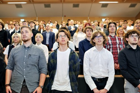 Kadry z inauguracji roku akademickiego w Audytorium Aleksandra Jabłońskiego - kolegium dziekańskie wraz z prorektorką za stołem oraz studenci i nauczyciele oraz administracja siedzący na sali. Kliknij, aby powiększyć zdjęcie.