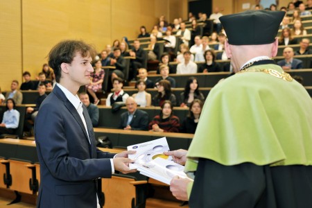 Kadry z inauguracji roku akademickiego w Audytorium Aleksandra Jabłońskiego - kolegium dziekańskie wraz z prorektorką za stołem oraz studenci i nauczyciele oraz administracja siedzący na sali. Kliknij, aby powiększyć zdjęcie.