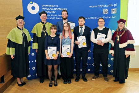 Kadry z inauguracji roku akademickiego w Audytorium Aleksandra Jabłońskiego - kolegium dziekańskie wraz z prorektorką za stołem oraz studenci i nauczyciele oraz administracja siedzący na sali. Kliknij, aby powiększyć zdjęcie.