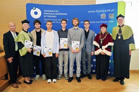 Kadry z inauguracji roku akademickiego w Audytorium Aleksandra Jabłońskiego - kolegium dziekańskie wraz z prorektorką za stołem oraz studenci i nauczyciele oraz administracja siedzący na sali. Kliknij, aby powiększyć zdjęcie.