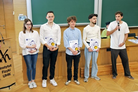 Kadry z inauguracji roku akademickiego w Audytorium Aleksandra Jabłońskiego - kolegium dziekańskie wraz z prorektorką za stołem oraz studenci i nauczyciele oraz administracja siedzący na sali. Kliknij, aby powiększyć zdjęcie.