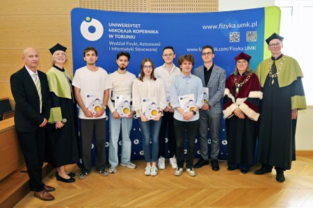 Kadry z inauguracji roku akademickiego w Audytorium Aleksandra Jabłońskiego - kolegium dziekańskie wraz z prorektorką za stołem oraz studenci i nauczyciele oraz administracja siedzący na sali. Kliknij, aby powiększyć zdjęcie.