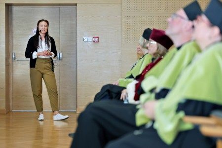 Kadry z inauguracji roku akademickiego w Audytorium Aleksandra Jabłońskiego - kolegium dziekańskie wraz z prorektorką za stołem oraz studenci i nauczyciele oraz administracja siedzący na sali. Kliknij, aby powiększyć zdjęcie.