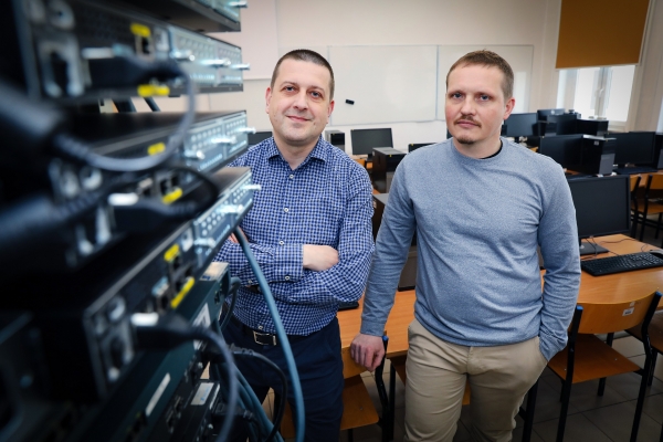 Two standing persons dr. hab. Piotr Masłowski, prof. UMK, and dr. hab. Mariusz Piwiński, prof. UMK