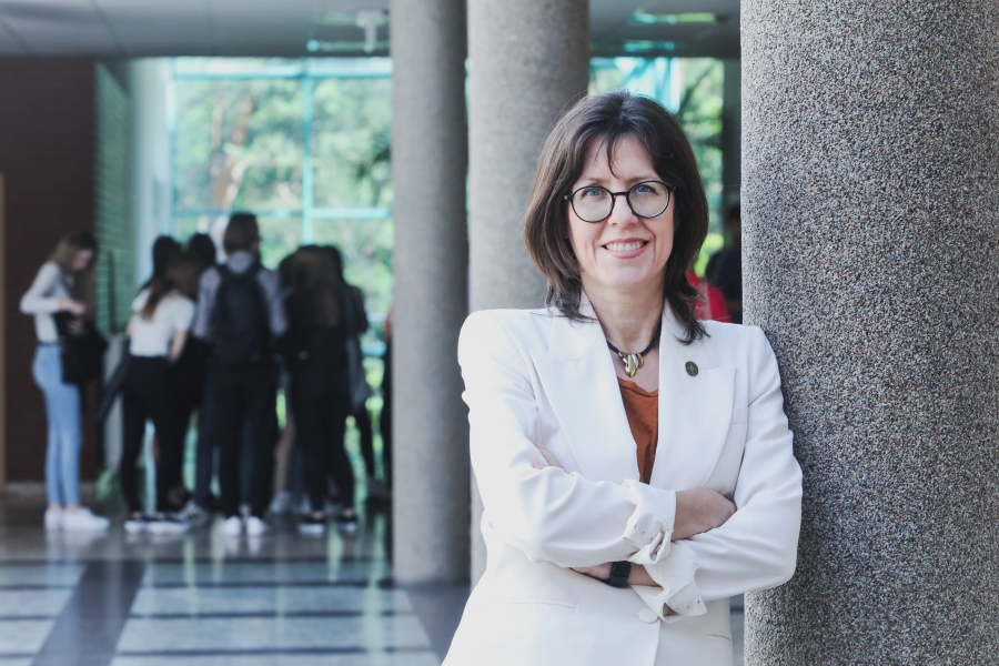 Na zdjęciu widoczna jest prof. Aldona Glińska-Neweś, stojąca przy filarze w budynku Wydziału Nauk Ekonomicznych i Zarządzania UMK w Toruniu