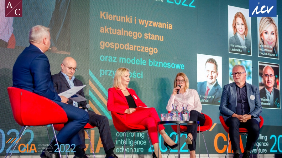 Czwórka osób: dwie kobiety i dwójka mężczyzn siedzi na scenie. 