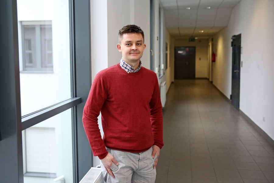 dr hab. Paweł Tecmer, prof. UMK stojący w holu Centrum Optyki Kwantowej na Wydziale