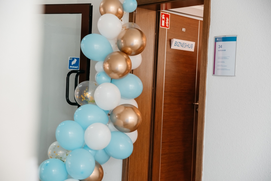 Zdjęcie otwartych drzwi, a wokół balony