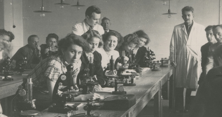 an old, black and white photo of the first students of the NCU in a laboratory