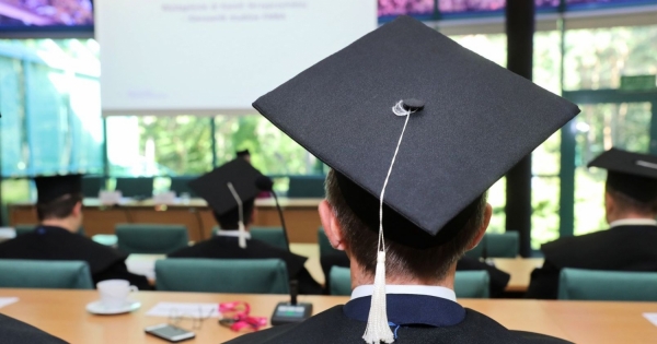 Person siting in class in university graduate hat.