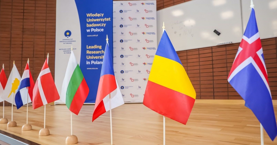Little flags from different countries, in the background there is a rollup with the inscription 