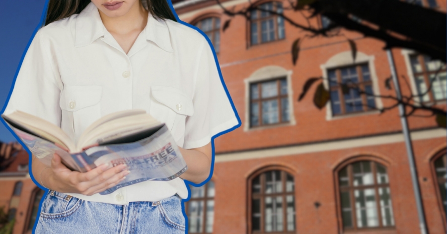 Dziewczyna trzyma w dłoniach grubą książkę. W tle budynek Collegium Maius