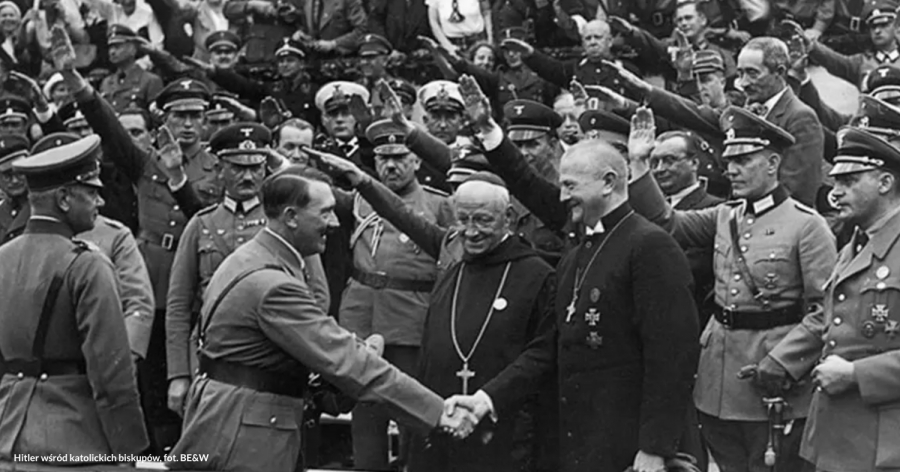 Czarno-białe zdjęcie przedstawia Adolfa Hitlera ściskającego dłoń jednego z katolickich duchownych w otoczeniu biskupów i niemieckich oficerów wykonujących nazistowski salut.