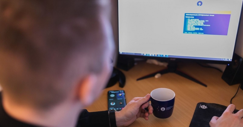 A student is sitting in front of a monitor displaying the Central Authentication Service screen