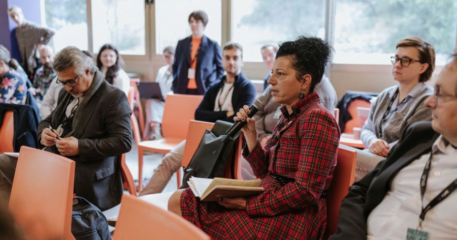 Prof. Bojana Ćulum Ilić holding a microphone during the conference