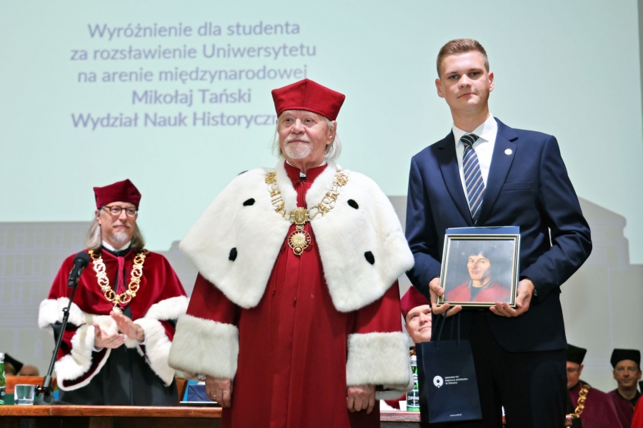 Mikołaj Tański odbiera wyróżnienie z rąk rektora UMK podczas inauguracji roku akademickiego