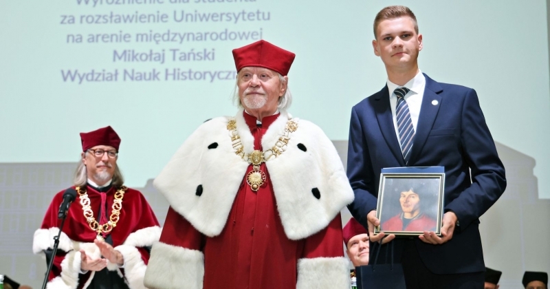 Mikołaj Tański odbiera wyróżnienie z rąk rektora UMK podczas inauguracji roku akademickiego