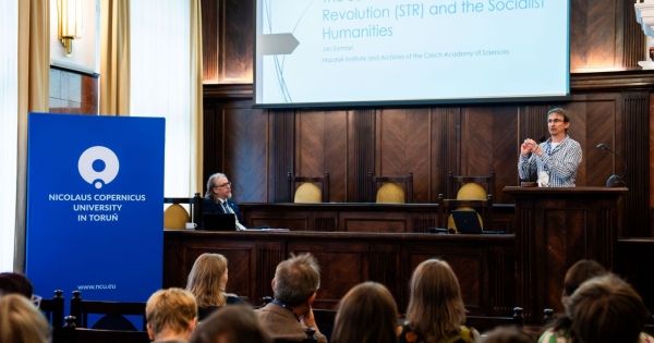 Wystąpienie konferencyjne - prelegent przemawia do uczestników, w tle ekran z prezentacją