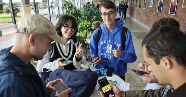 A few students with cell phones and playing cards while working on their assignments