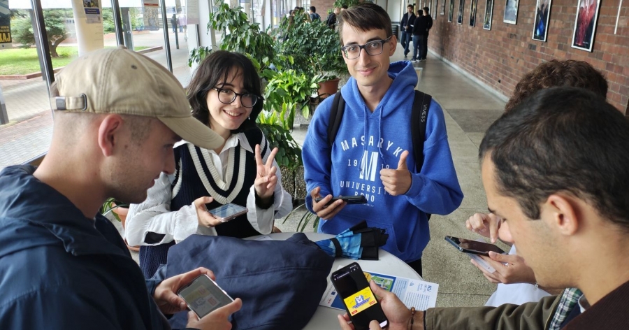 A few students with cell phones and playing cards while working on their assignments